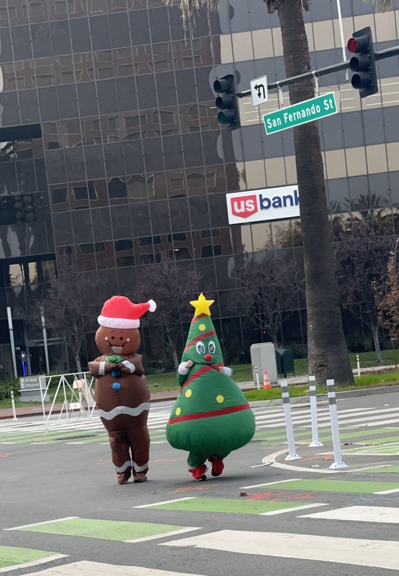 Inflatable gingerbread and Christmas tree costumes walking downtown