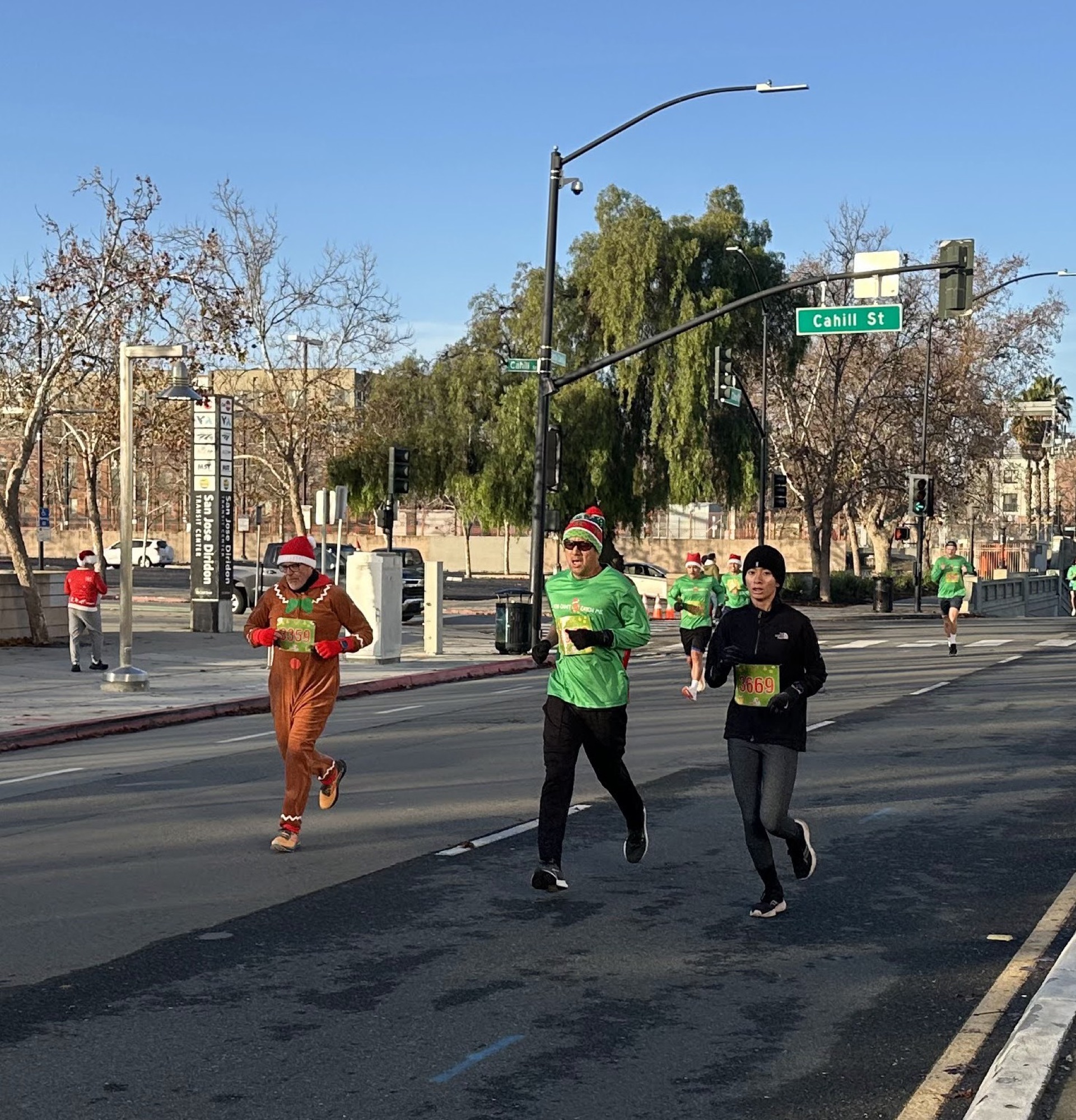 Runners in a gingerbread costume and green shirts on the course