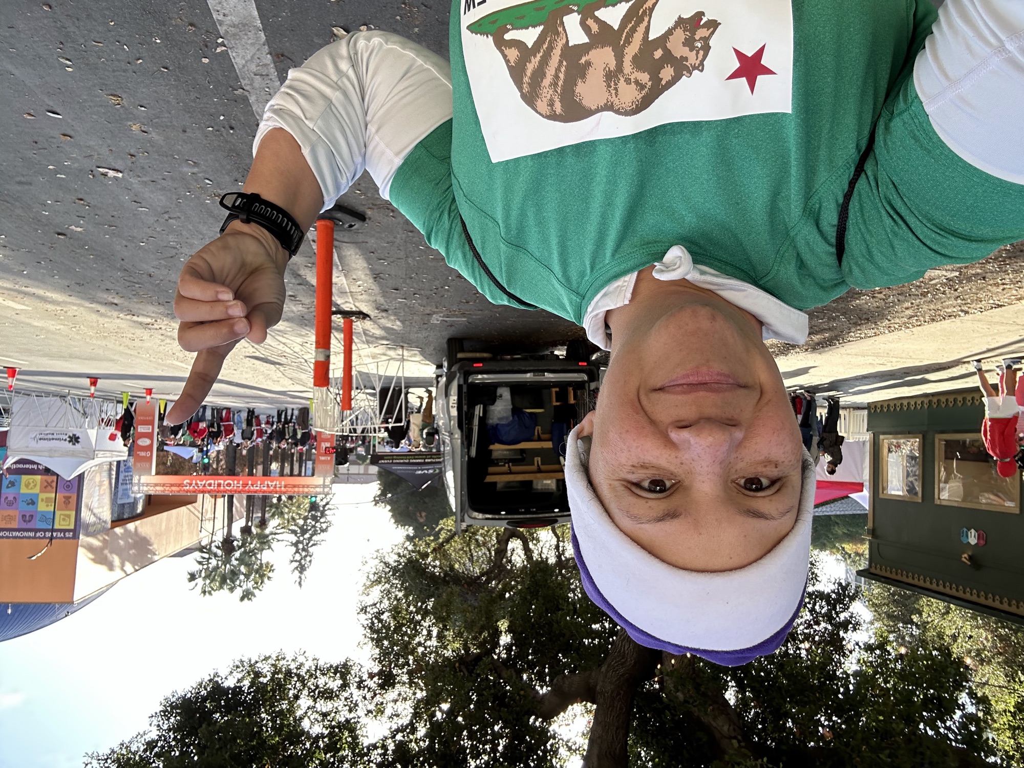 Coach Sabrina in a Santa hat taking a selfie near the Santa Run finish area